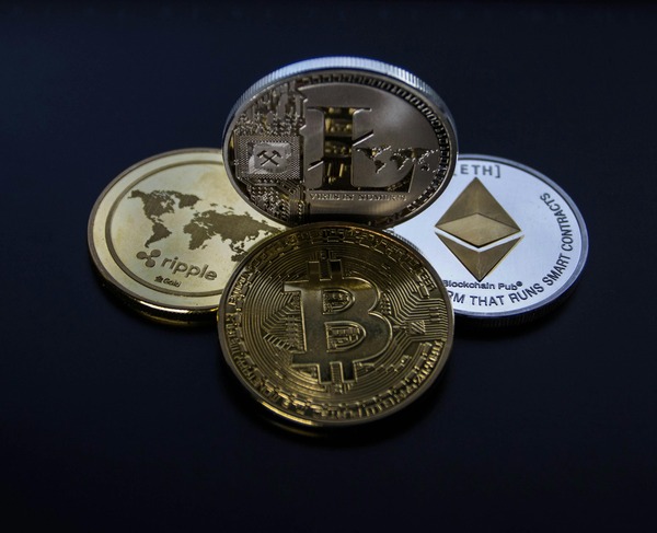 Bitcoin, Ethereum, Ripple and Litecoin coins arranged together on a dark background