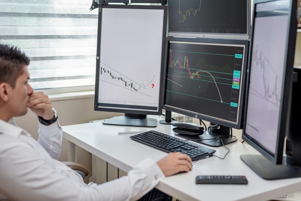 Trader reviewing crypto market charts across several monitors before a SUI to SOL exchange